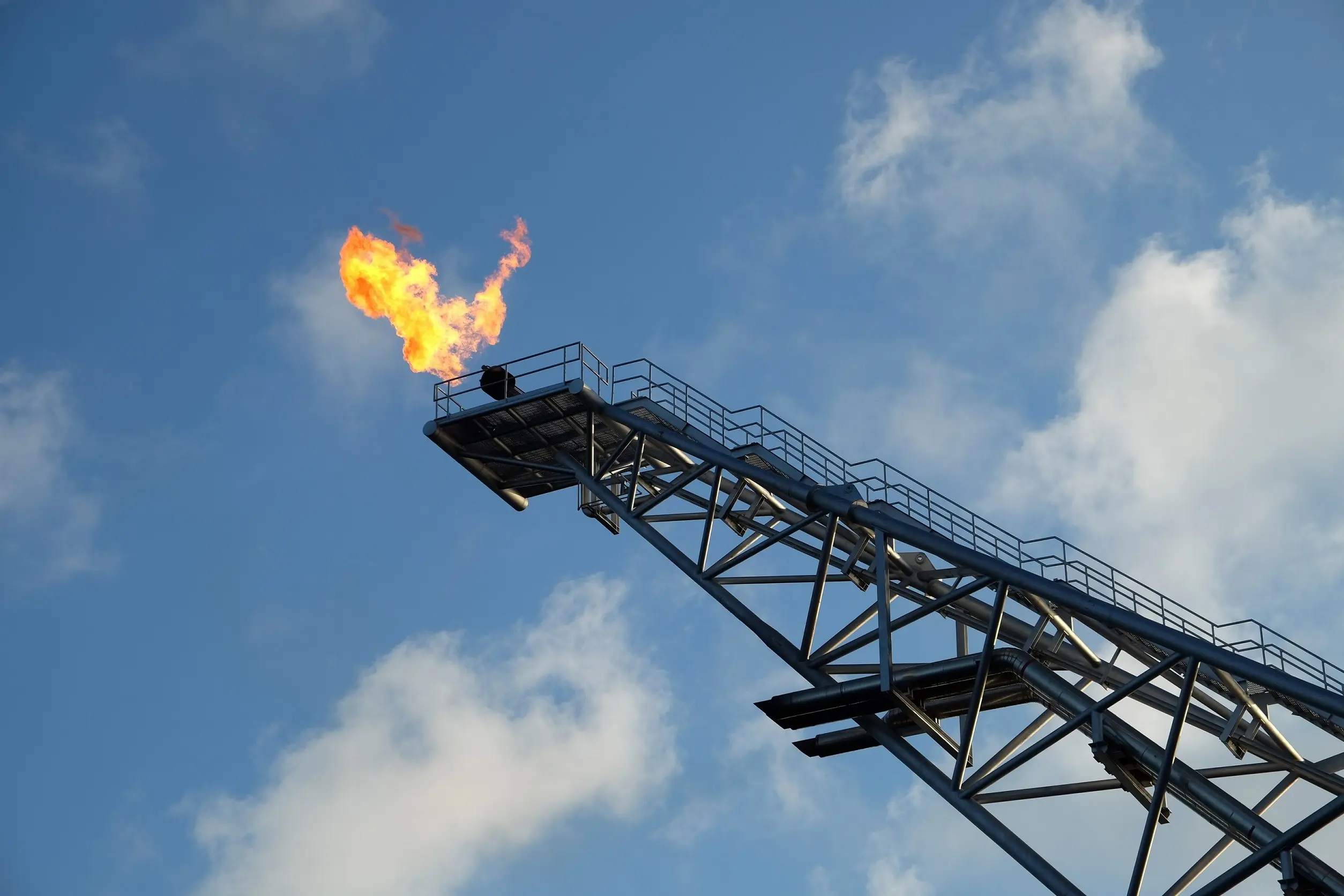 Branchen: OEMs und Anlagenbauer, dargestellt durch einen Fackelturm, dessen Flammen sich vor dem blauen Himmel abheben