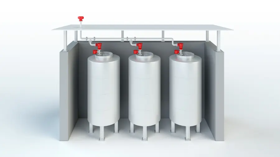 Una representación en 3D muestra tres depósitos de almacenamiento verticales bajo un techo, conectados por tuberías aéreas con válvulas de ventilación de seguridad rojas en la parte superior.