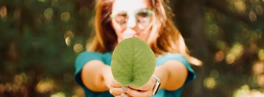 Holding a green leaf, symbolizing sustainability, engagement, and our commitment to environmental responsibility